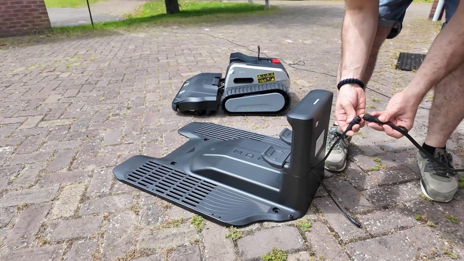 Het laadstation en de RTK antenne worden in elkaar gezet op een beklinkerde oprit