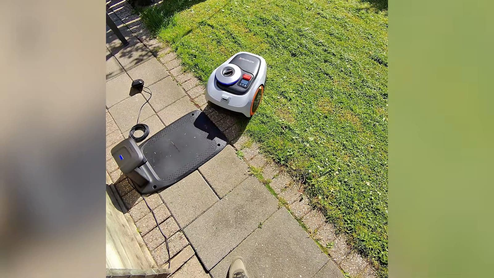 Navimow i2 AWD robotmaaier die automatisch achteruit het laadstation inrijdt op het terras