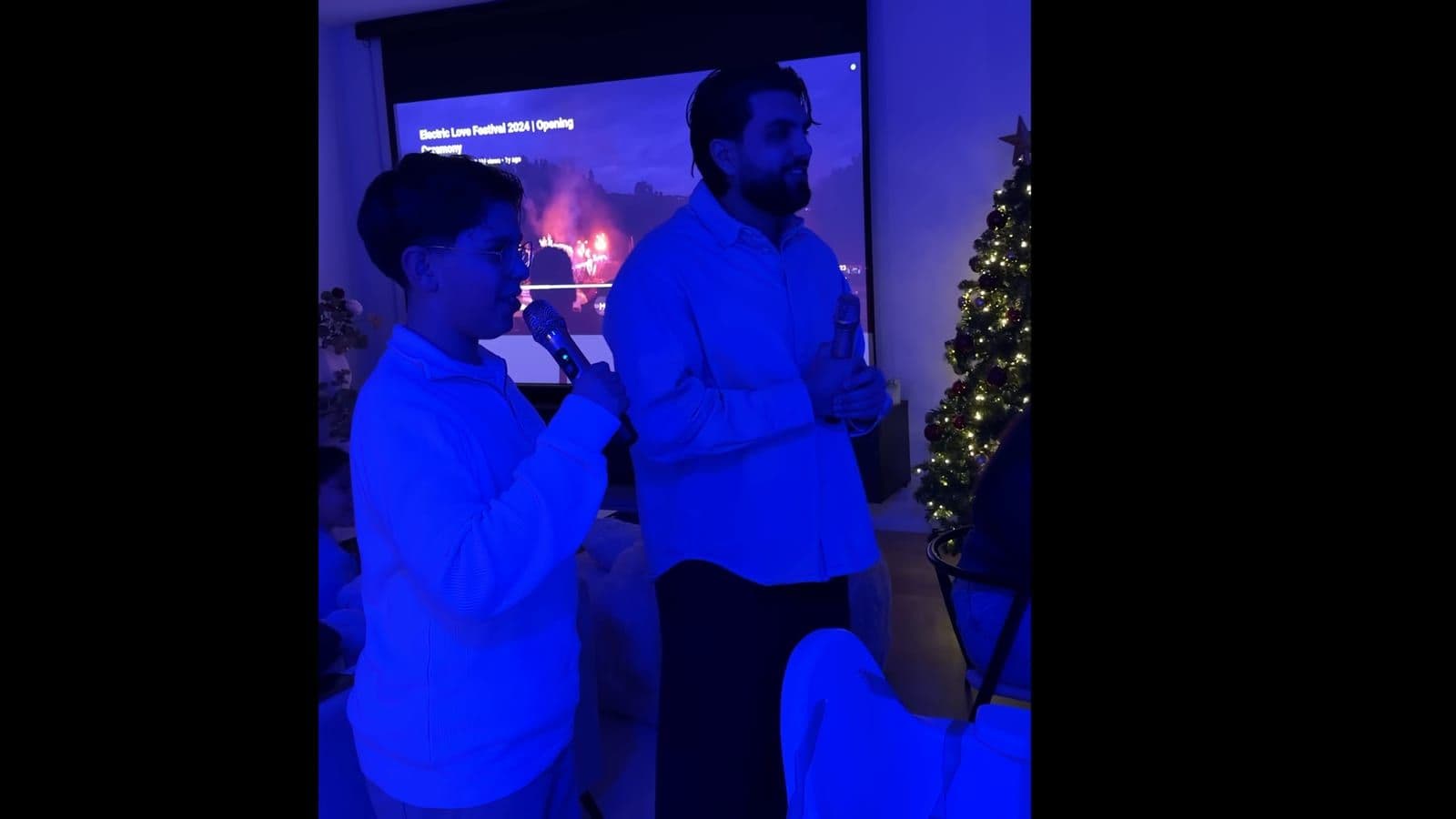 Two people singing into the wireless microphones during the indoor karaoke test