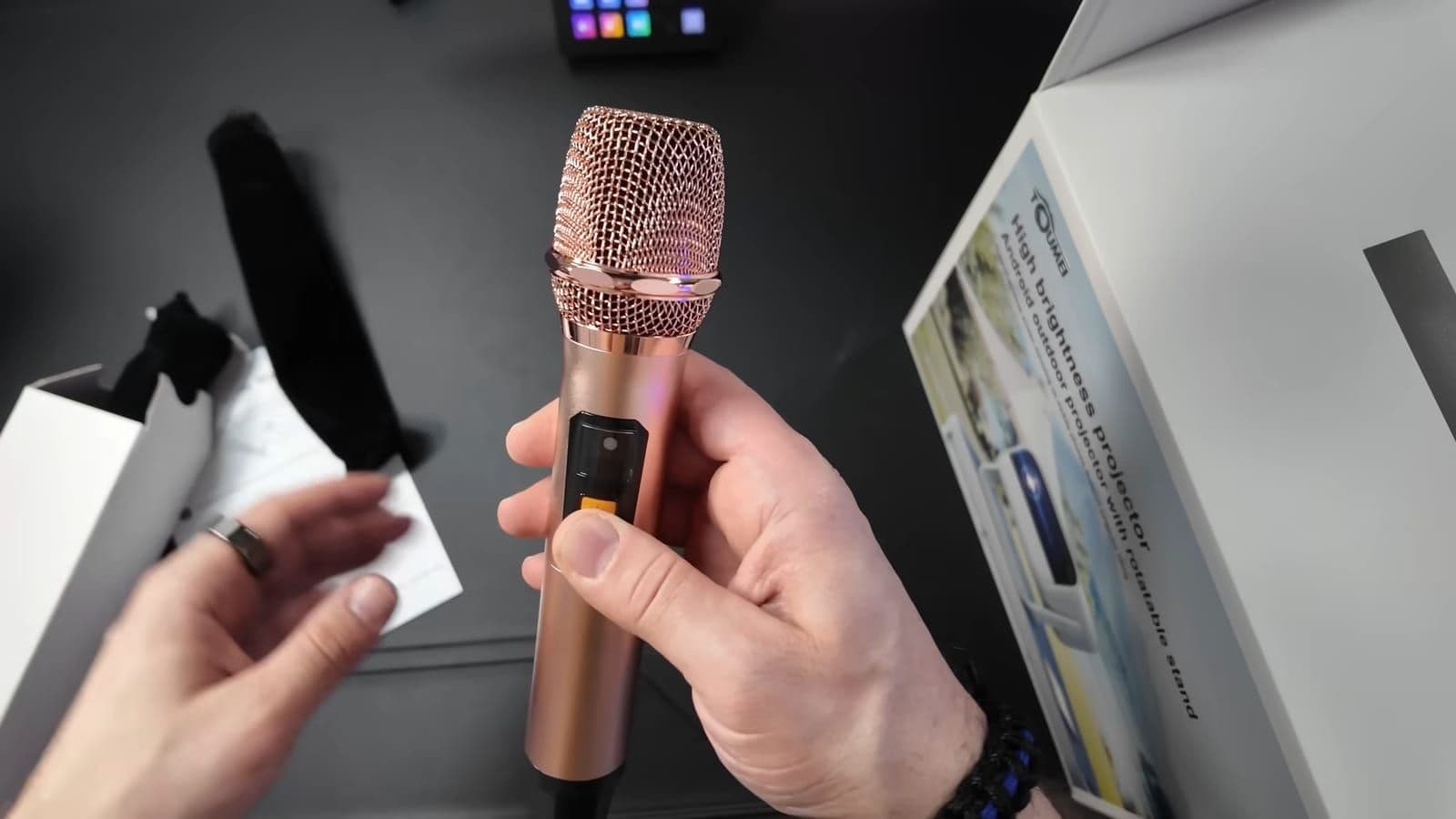 Unboxing shot showing one of the two included rose-gold aluminum wireless microphones