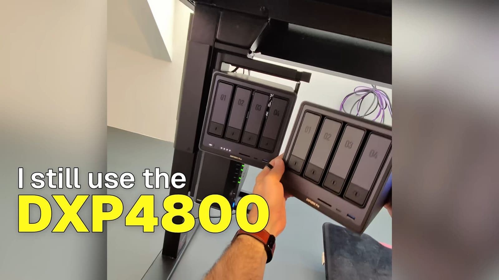 The DXP4800 Pro held alongside an older DXP4800 Plus mounted underneath a standing desk