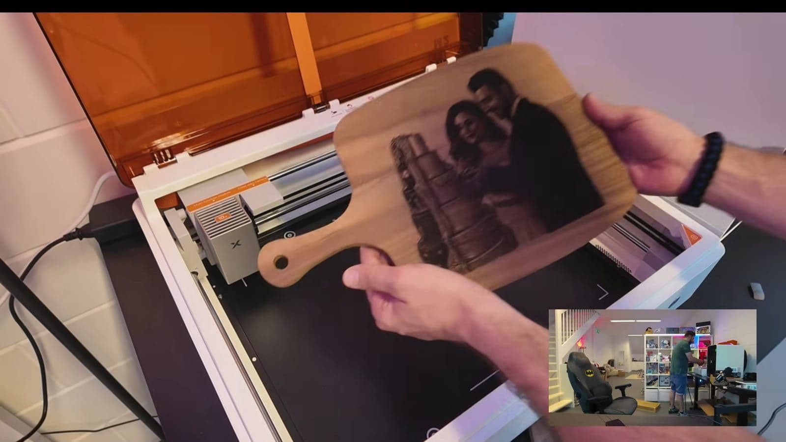 Zino toont de voltooide snijplank met de gegraveerde trouwfoto in walnoothout